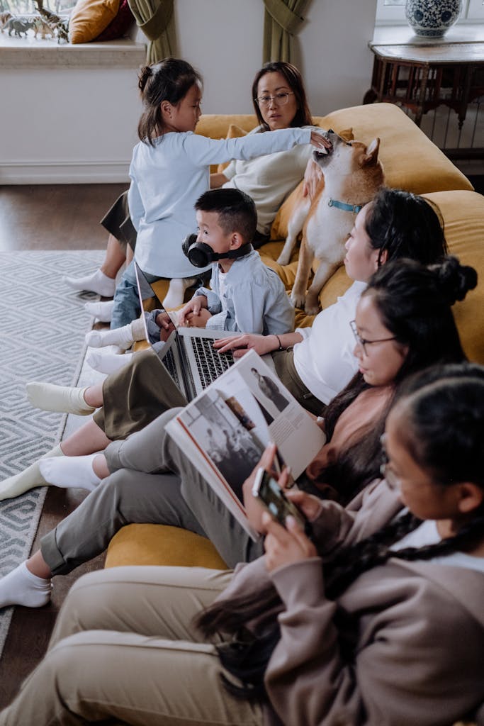 A family bonding in a cozy living room with their pet dog, engaging in leisure activities.