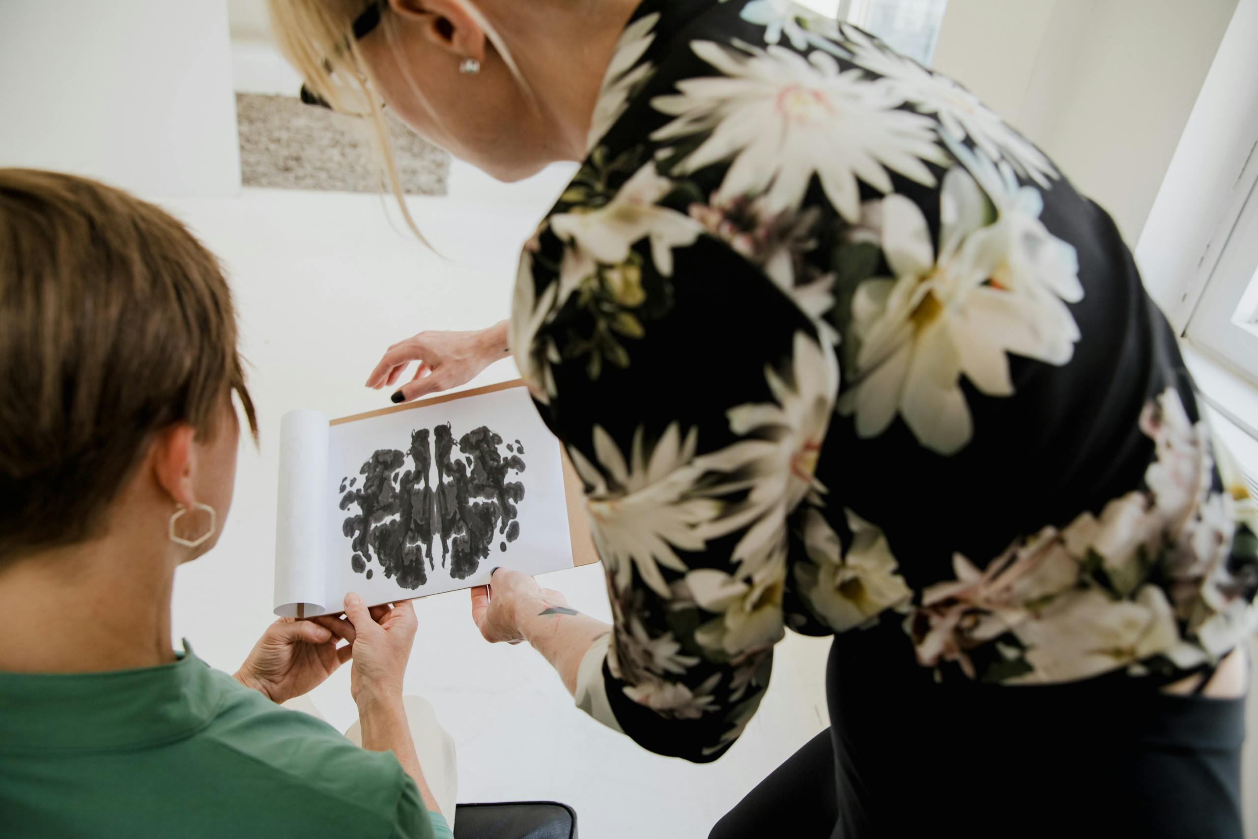 A therapist and patient analyze a Rorschach inkblot test in a counseling session.